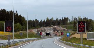 Tunneli ja tyhjä ajokaista opasteineen.